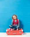 Child blonde girl with pink vintage suitcase ready for summer vacation. Travel and adventure concept