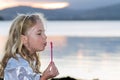 Child blowing bubbles by the sea