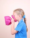 Child blowing pink paper bag Royalty Free Stock Photo