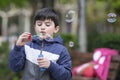 Child blowing soap bubbles outdoors