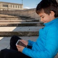 Smiling young boy sitting on the floor using a digital tablet Royalty Free Stock Photo