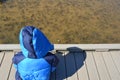 Child in blue jacket sitting on boardwalk looking at plants in water Royalty Free Stock Photo