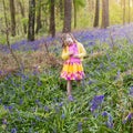 Child with bluebell flowers in spring forest