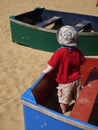 A child in a boat floating on sea of sand