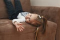 The child is bored lying in a wide chair. Royalty Free Stock Photo