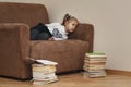 The child is bored lying in a wide chair. Royalty Free Stock Photo