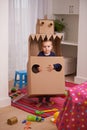 Child, box and play for robot and imagination in bedroom for fun and recreation in home on weekend. Young kid, toddler Royalty Free Stock Photo