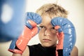 Child with boxing gloves focusing on punching pad Royalty Free Stock Photo