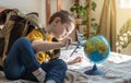 A child boy with backpack is playing with a toy airplane and a globe of the earth. Going on a journey towards adventure Royalty Free Stock Photo