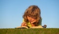 Child boy with a book in the garden. Kid is readding a book playing outdoors in summer day. Kids imagination, innovation Royalty Free Stock Photo