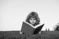 Child boy with a book in the garden. Kids success, successful leader concept. Kid is readding a book playing outdoors in Royalty Free Stock Photo