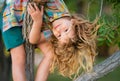 Child boy climbing high tree in the summer park. Portrait of cute kid boy sitting on the tree, climbing a tree. Active Royalty Free Stock Photo