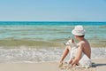 Child boy with dog jack russel on beach. Best friends rest on vacation, play in sand against sea. Tourism and vacation on ocean. Royalty Free Stock Photo