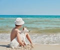 Child boy with dog jack russel on beach. Best friends rest on vacation, play in sand against sea. Tourism and vacation on ocean. Royalty Free Stock Photo