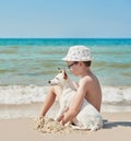 Child boy with dog jack russel on beach. Best friends rest on vacation, play in sand against sea. Tourism and vacation on ocean. Royalty Free Stock Photo