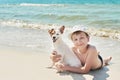 Child boy with dog jack russel on beach. Best friends rest on vacation, play in sand against sea. Tourism and vacation on ocean. Royalty Free Stock Photo