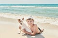 Child boy with dog jack russel on beach. Best friends rest on vacation, play in sand against sea. Tourism and vacation on ocean. Royalty Free Stock Photo