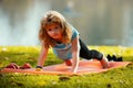 Child boy is doing push up exercise in spring park. Healthy activities kids lifestyle. Strong child exercising in park Royalty Free Stock Photo