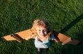 Child boy dreams and travels on green grass in park. Boy with airplane toy outdoors. Happy child playing with toy Royalty Free Stock Photo