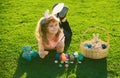 Child boy with easter eggs and bunny ears outdoor painting eggs. Cute kid having happy easter in park. Royalty Free Stock Photo