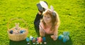 Child boy with easter eggs and bunny ears outdoor painting eggs. Cute kid having happy easter in park. Horizontal photo Royalty Free Stock Photo