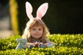 Child boy with easter eggs outdoor. Easter egg hunt. Fynny kids face. Happy easter day. Child with bunny ears. Royalty Free Stock Photo