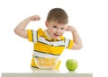 Child boy eating healthy food and showing his strength, isolated on white Royalty Free Stock Photo