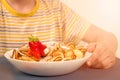 Child boy eating healthy trendy mini baby pancakes cereal and strawberries from white bowl. No face image, family concept. Healthy Royalty Free Stock Photo