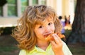 Child boy eating a piece of pizza. Kid eats a slice of pepperoni pizza. Kids love pizza.