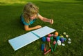 Child boy enjoying art and craft drawing in backyard or spring park. Children drawing draw with pencils outdoor.