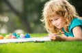 Child boy enjoying art and craft drawing in backyard or spring park. Children drawing draw with pencils outdoor Royalty Free Stock Photo