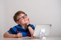 Child boy in glasses think and dream. Kid of primary school reading book. Online remote computer education. Child having Royalty Free Stock Photo