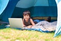 Child, boy and happy with laptop in tent for camping, social media and online movie with portrait in nature. Person Royalty Free Stock Photo