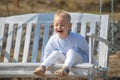 Child boy having fun on a swing. Adorable little kid having fun on a swing outdoor. Spring kids portrait. Kid emotions