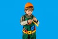 Child boy in helmet and toolbelt with hammer. Little repairman or craftsman with tools for building. Kid in builder Royalty Free Stock Photo