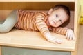 Child boy hiding in cupboard Royalty Free Stock Photo