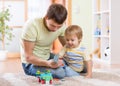 Child boy and his father repair toy car at home Royalty Free Stock Photo