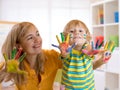Child boy and his mom with painted hands. Kid drawing and coloring with teacher in daycare center or playschool. Royalty Free Stock Photo