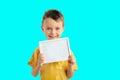 Child boy  holding a poster for your information on the blue background Royalty Free Stock Photo