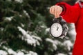 A child boy holds a clock alarm clock in his hands.Winter d Royalty Free Stock Photo