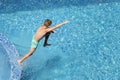 Child boy jumping into blue water of hotel swimming pool. Summer fun, kids sports activities for children vacation Royalty Free Stock Photo