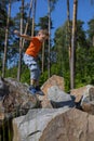 Child boy jumping from stone to stone in summer. The boy cheerfully jumps on the mountain in a summer journey. A child