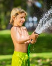 Child, boy or kid plays with water hose outdoors Royalty Free Stock Photo