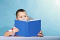 Child boy kid reading a book on blue