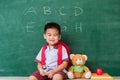 Child boy kindergarten preschool in student uniform with school bag, book sit with teddy bear