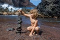 Child boy making stack of pebbles stone against sea background for spa, balance, meditation and zen theme. Royalty Free Stock Photo