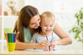 Child boy and mother draw with colorful pencils