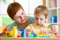 Child boy and mother playing colorful clay toy