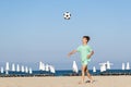 Child boy play with soccer ball on sandy beach during summer holiday. Childhood, summertime, kids fun game. copy space Royalty Free Stock Photo