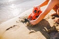 Child boy playing on the beach near the river toy red tractor